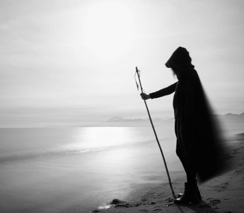 Silhouette of a person in a meditative pose against a dark background.